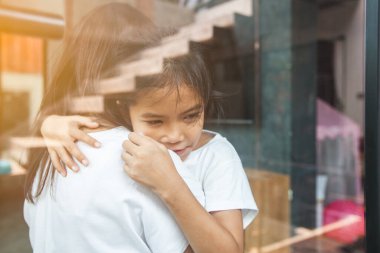 Asyalı çocuk annesine sarılıyor ve Coronavirus Covid-19 ve hava kirliliği pm2.5 yüzünden karantinada kalıyor..