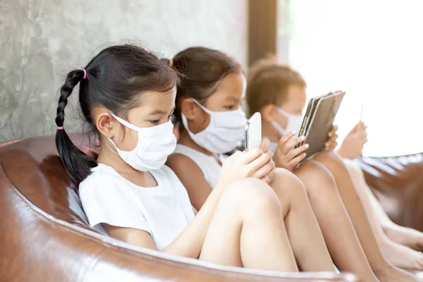 Asiático Crianças Menino Meninas Vestindo Máscara Proteção Jogando Smartphone Juntos — Fotografia de Stock