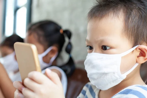 Asiático Crianças Menino Meninas Vestindo Máscara Proteção Jogando Smartphone Juntos — Fotografia de Stock