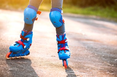 Çocuk parkta paten kayıyor.