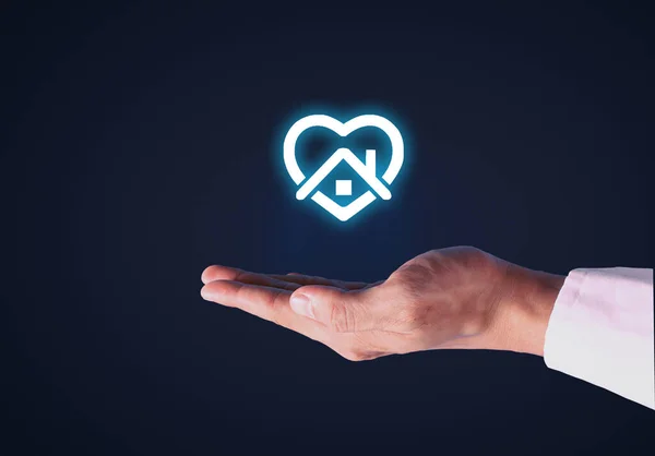 İş adamı ev sembolü olarak kalmayı teklif ediyor. Güvenli yaşam konsepti için evde kal