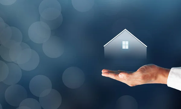 İş adamı ev sembolü olarak kalmayı teklif ediyor. Güvenli yaşam konsepti için evde kal