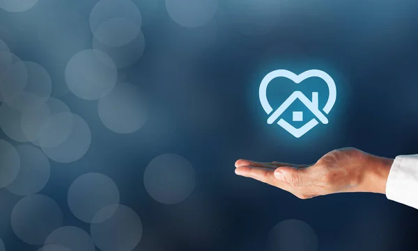 İş adamı ev sembolü olarak kalmayı teklif ediyor. Güvenli yaşam konsepti için evde kal