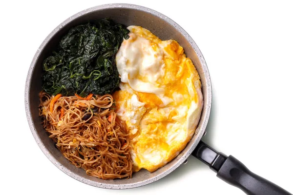 homemade pan fried noodles with fried eggs and spinach on white background, healthy gourmet food recipe, good work from home lunch idea
