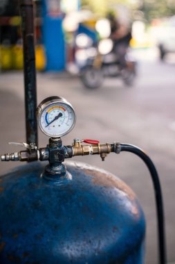 Benzin istasyonundaki lastik şişirme detayı. Lastiğe hava doldurmak için kullanılan eski hava basıncı tankı. Sığ alan derinliği.