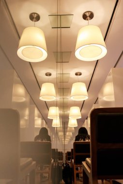Modern kütüphane veya kafede iç aydınlatma, tavan lambalarının yansıması