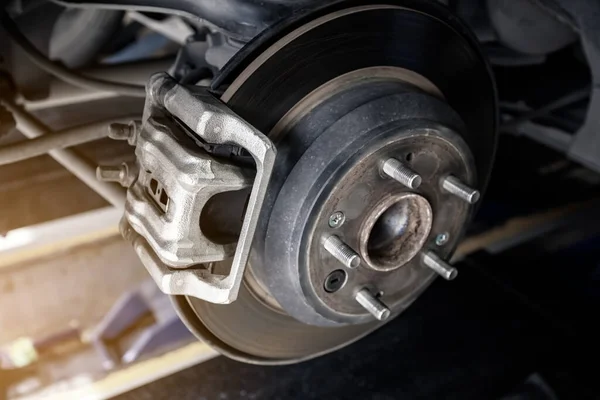 modern araba disk freni garajda ya da otomotiv servis istasyonunda tamir edilecek güneş ışığı efektli, sığ alan derinliği