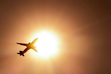 Uçak güneşte uçuyor.