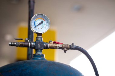 Benzin istasyonundaki lastik şişirme detayı. Lastiğe hava doldurmak için kullanılan eski hava basıncı tankı. Sığ alan derinliği.
