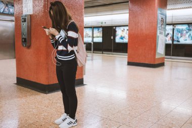 Tanımlanamayan yolcu, Hong Kong metro sisteminde yoğun saatlerde akıllı telefonu tarıyor.