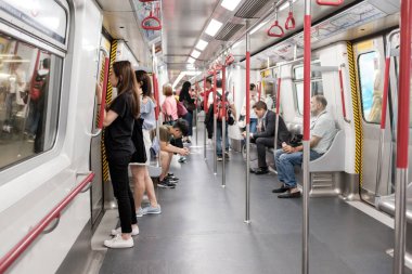 Tanımlanamayan yolcular yoğun saatlerde Hong Kong metro sisteminde akıllı telefonlara bakıyorlar.
