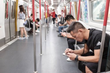 Hong Kong metro sistemindeki kimliği belirsiz yolcular yoğun saatlerde, sığ alan derinliğinde.