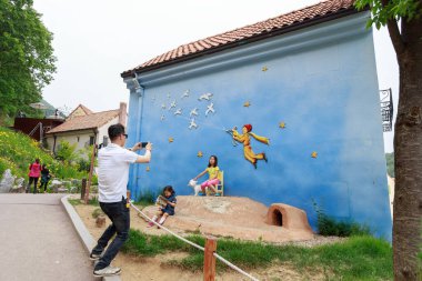Babam, Güney Kore 'nin Gyeonggi Eyaleti' nde Temmuz 2008 'de inşa edilen Fransız tarzı bir tema parkı olan Petite France' da şirin duvarlı çocuklarının fotoğrafını çekiyor..
