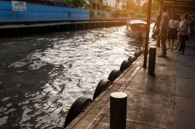 Saen Saep ekspres teknesi akşam trafiğinin yoğun olduğu saatte iskeleye yaklaşıyor. Saen Saep kanalı Bangkok 'taki bir ekspres tekne servisi tarafından toplu taşıma için kullanılır.