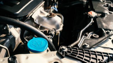 Modern araba motorunun ayrıntıları, ön cam yıkama tankı işareti, sığ alan derinliği