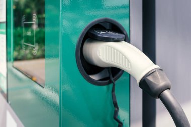 Alış veriş merkezinin otoparkındaki şarj istasyonundaki prize takılı elektrikli araca veya elektrikli arabaya güç kaynağı bağlantısı. Gelecekteki otomotiv ve şehir yaşamı için şarj teknolojisi.