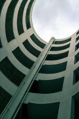 Bir binanın arka planında park alanı için sarmal rampa eğiminin soyut geometri perspektifi, tavan pencereli çekici dış dekorasyon, geometrik desen mimarisi
