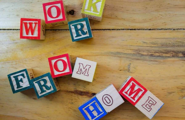 Virüs salgını sırasındaki tecrit talimatları sırasında evden çalışma kavramı. WorkFROMHOME 'u oluşturan tahta alfabe küpleri. Sadece seçici küplere odaklan.