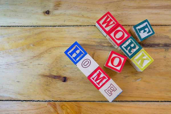 Virüs salgını sırasındaki tecrit talimatları sırasında evden çalışma kavramı. WorkFROMHOME 'u oluşturan tahta alfabe küpleri. Sadece seçici küplere odaklan.