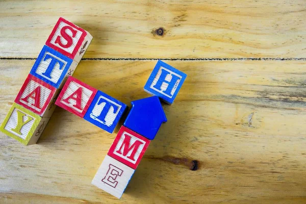 Conceptual of stay at home during movement control order to stop the chain of virus outbreak. Wooden alphabet cubes forming words WORK FROM HOME. Focus on selectve cubes.
