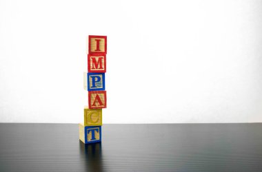 Gri arkaplanlı IMPACT metinleriyle izole edilmiş ahşap küpler. Salgınlardan, savaşlardan, çatışmalardan kaynaklanan finansal ve ekonomik belirsizliklerin kavramsal etkisi. Seçici tahta küplere odaklan.