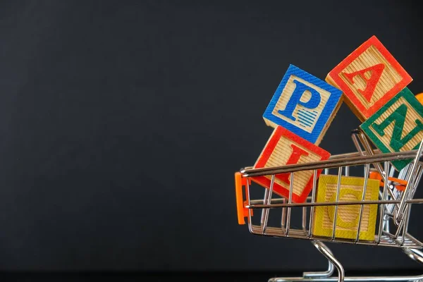 Virüs salgını sırasında yiyecek ya da market alışverişi ya da ciddi kriz kavramı. Tahta küpler, karanlık ve tozlu yüzeyde mini tramvayda aşırı yüklendi. Seçici küplerin odağı.