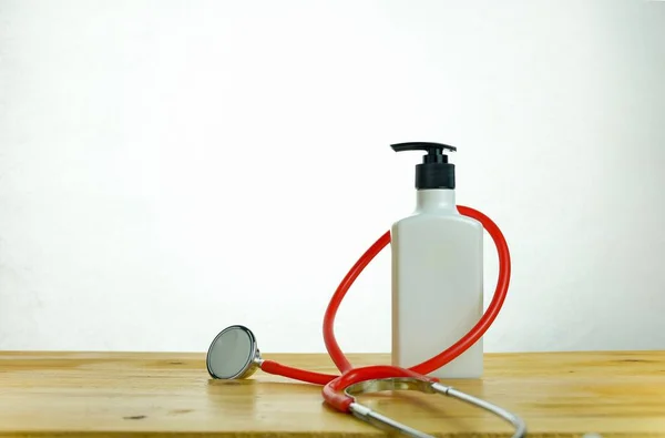 Koronavirüs salgını sırasında hijyenik ve dezenfekte edilmiş kalma kavramı. Yüz maskelerindeki el dezenfektanı beyazın üzerinde izole edilmiş. Siyah şeker pompasına odaklan.