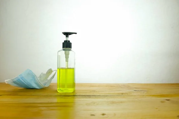 Ölümcül virüs salgını sırasında temiz kalmanın kavramsal görüntüsü. Parmak sıkma el dezenfektanı pompası ahşap masada beyaz üzerine izole edilmiş. Siyah şeker pompasına odaklan.