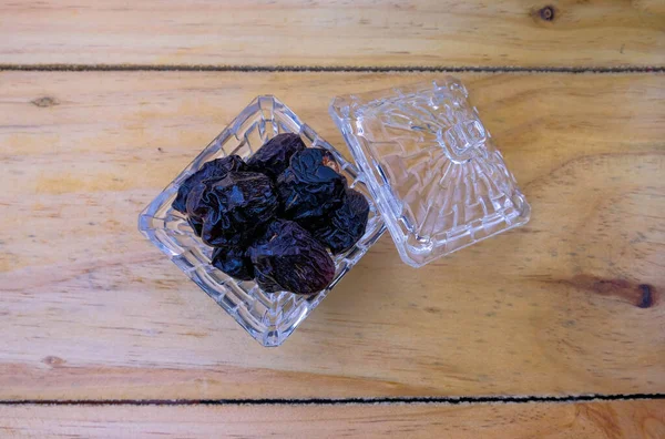 Kahvaltı ve ramadhan ayı kavramı. Ahşap masanın üstündeki cam kaplamalı hurmaların en üst görüntüsü. Yüksek oranda doğal şeker ve bol miktarda besin..