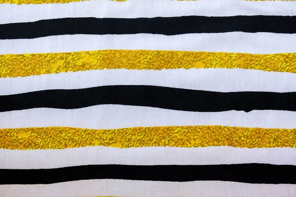 Tekstil üzerinde beyaz sarı siyah çizgili görüntü.
