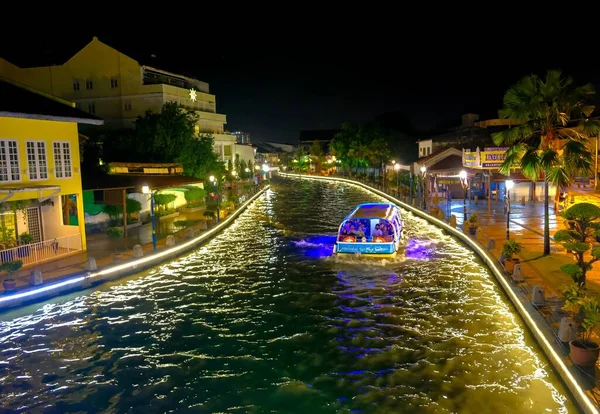 Malacca Malezya-202020Ocak 4: Yürüme yolunun yanı sıra gece Malacca Nehri 'nin güzel manzarası. Görünürde hareket bulanıklığı var. Ön plana yakın yürüme yoluna odaklan. Biraz tahıl ya da gürültü ve düşük ışıkta hafif odaklanma.