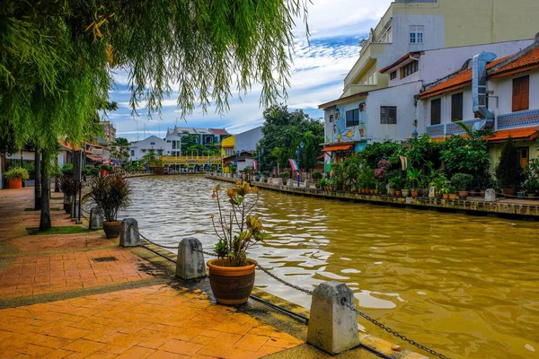 Malacca City, Malezya - 2019 Aralık 19: Yaya geçidi, nehir kenarındaki yenilenmiş binalar ve mavi gökyüzü ile güzel bir Malacca nehri. Nehir yolculuğu rotası. Önplanda seçmeli odak.