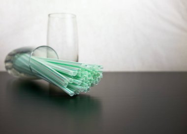Yan görüş yüzeyinde camdan başka plastik pipetler de var. Yeniden kullanılabilir çelik kamışa karşı tek kullanımlık plastik üzerine kavramsal dünya baskısı. Merkezdeki pipetlerde seçici odak.
