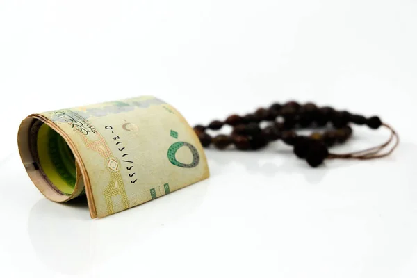 Suudi riyal banknotunun yansıtıcı beyazdan çok SR100 banknotlu hali. Banknotlara odaklan. Görünürde boncuklar.