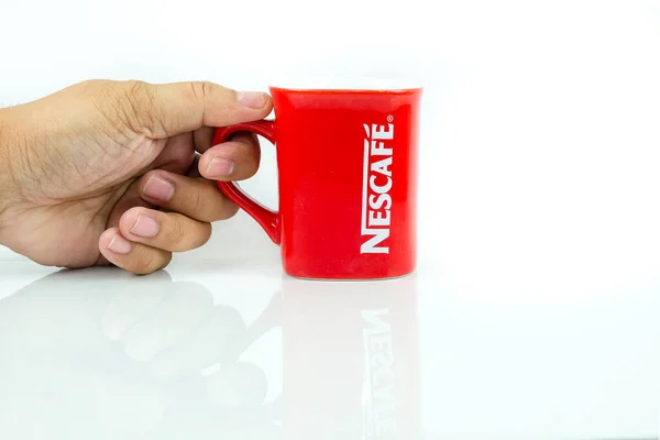 Kuala Lumpur Malezya - 2020 Haziran 6: Beyaz üzerine izole edilmiş Nescafe kırmızı kupası. Kupaya odaklan. Masada yansıma.