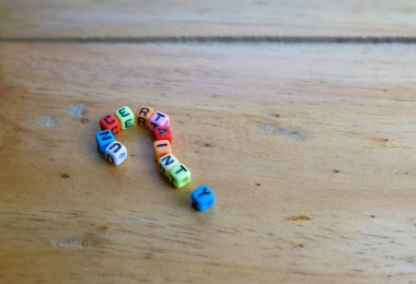 Alfabe boncukları tahtadan masa üzerinde soru işareti şeklinde UNCERTAINTY. Seçici odak.