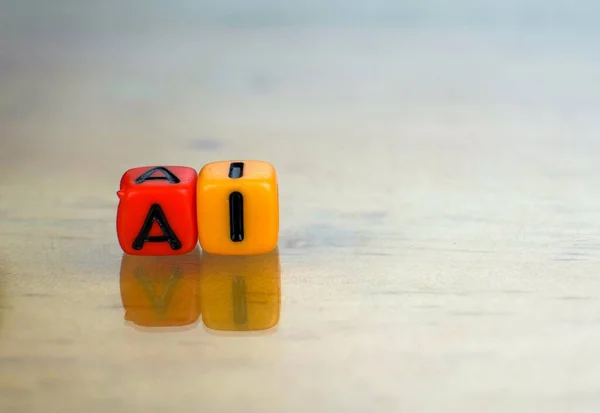 Conceptual of artificial intelligence in future information technology. 2 Colorful alphabet bead stacked on each other isolated on reflective surface. Focus on texts on beads. Others gradient blur.