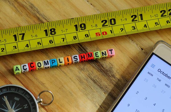 Image of measuring life and business success concept. Colorful alphabet beads spelling succesz and green measuring tape. Only beads in focus; other in blurs. Gradient bur white background.
