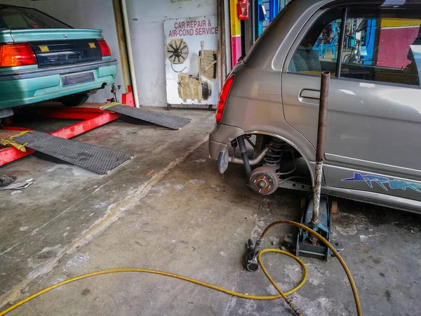 Atölyenin dışında gölgelik altında tamir edilmiş bir otomobilin görüntüsü. Seçici odaklanma. Doğal öğleden sonra ışığı.