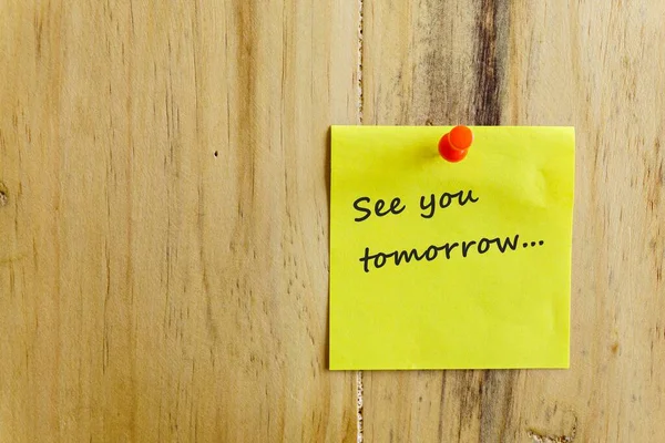 İş dünyasındaki zaman yönetimindeki dakikliğin kavramsal görüntüsü. Hatırlatayım, yarın açık kahverengi ahşap duvara iğnelenmiş yapışkan notta görüşürüz. Nota odaklan.