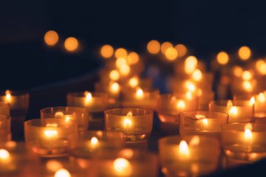 Ilık ışıklarla kilise mumları yaktı.