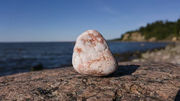 Açık bir günde, körfezin kıyı şeridinin arka planında taş üstüne taş..