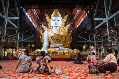 Yangon, Myanmar. 14 Ağustos 2019: Burmalı insanlar bir pagoda içinde Buda heykeline dua ediyorlar.