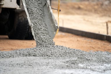 İnşaat işçisi inşaat alanına beton döküyor.
