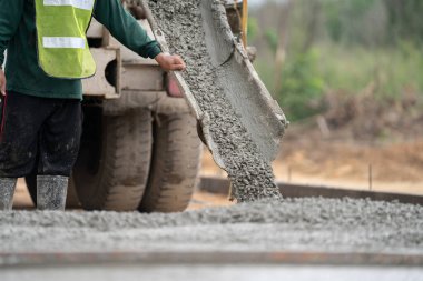 İnşaat işçisi inşaat alanına beton döküyor.