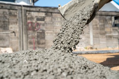 İnşaat işçisi inşaat alanına beton döküyor.