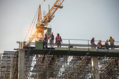 İnşaat alanında çalışan miğferli inşaat işçilerinin düşük açılı görüntüsü.