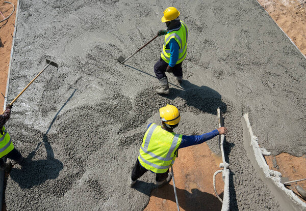 Construction worker pouring concrete at construction site