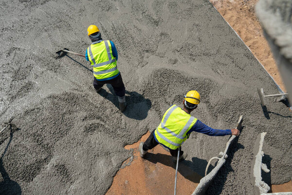 Construction worker pouring concrete at construction site