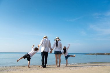 Çocuklu ebeveynler sahilde tatilin tadını çıkarıyorlar.